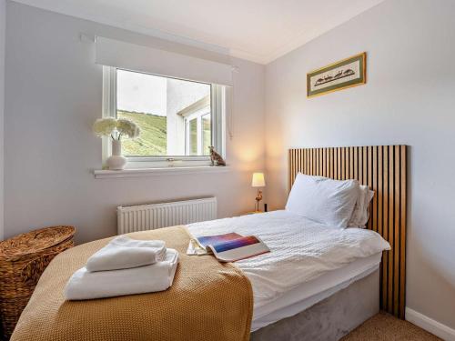 a bedroom with a bed with a book on it at 5 Bed in Dunbar oc-94334 in Dunbar