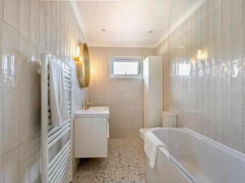 a white bathroom with a tub and a sink at 5 Bed in Dunbar oc-94334 in Dunbar