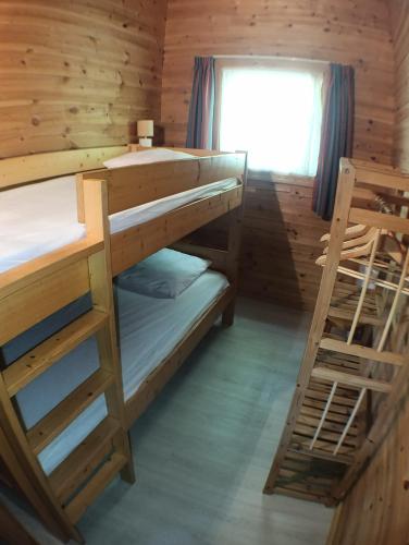 a room with two bunk beds and a window at Le Havre Sylvestre Séjour nature avec piscine in Mauroux