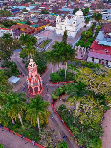 an aerial view of a city with a building and palm trees at La Casa de Mamapán Hotel Colonial Ahuachapan in Ahuachapán