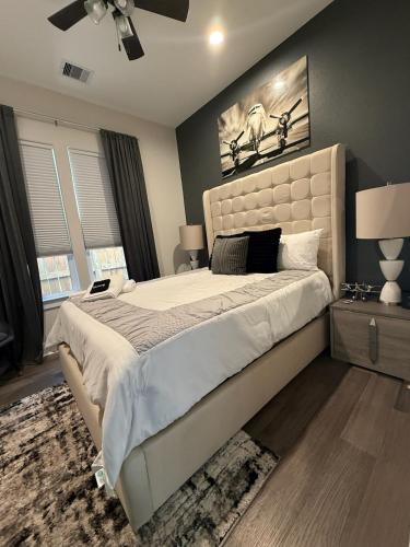 a bedroom with a large bed with a white bedspread at The Grand Harris in Houston
