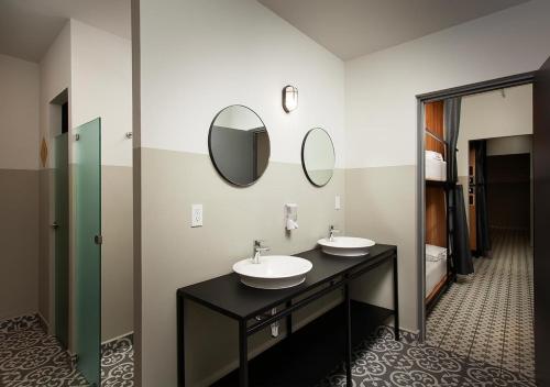 a bathroom with two sinks and two mirrors at Hostal CASA MX centro in Mexico City