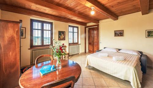a bedroom with a bed and a table with flowers on it at Villa Bricco Paglieri in Alba
