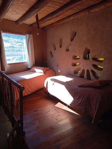a bedroom with two beds and a window at Los Amarantos in Tilcara