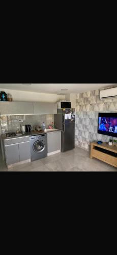 a kitchen with a sink and a refrigerator and a tv at ויקשיין in Eilat