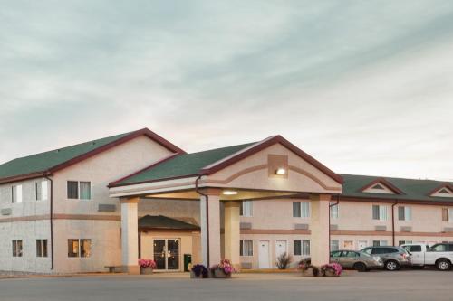 a large building with cars parked in a parking lot at Super 8 by Wyndham Kindersley in Kindersley