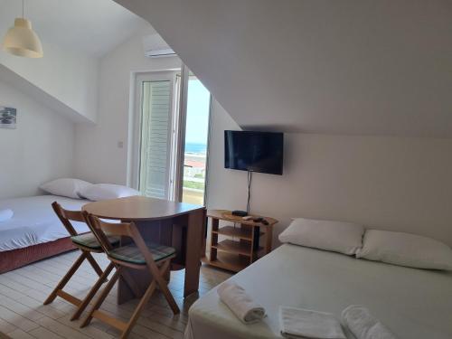 ein Schlafzimmer mit einem Bett, einem Schreibtisch und einem Tisch in der Unterkunft View - Novalja in Novalja