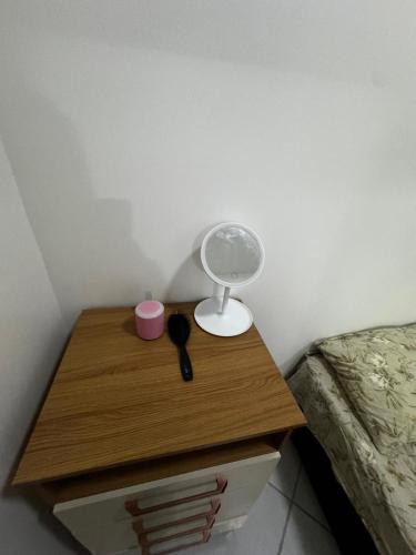 a nightstand with a lamp on it next to a bed at Ap FIG Garanhuns in Garanhuns