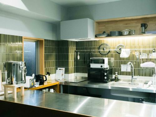 a kitchen with a sink and a counter top at KéFU stay & lounge in Kyoto