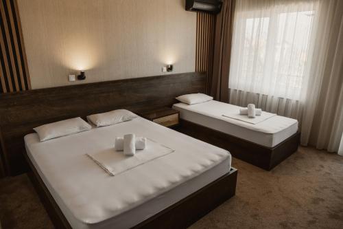 a room with two beds and a window at Hotel Istatov in Nov Dojran