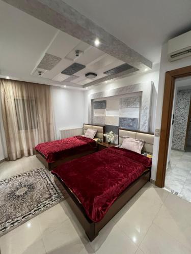 a bedroom with two beds with red comforter at Residance Panorama 52 in Sousse
