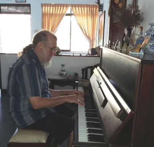 a man sitting in front of a piano at Serenity in Kandy