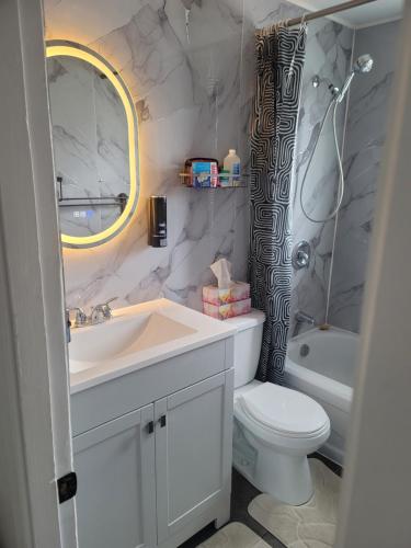 a bathroom with a white sink and a toilet at Downtown apartment next to highway netflix+wifi in Edmundston