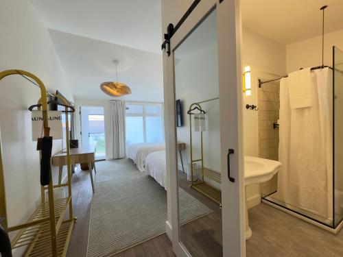 a bathroom with a bed and a shower and a sink at The Montauk Beach House in Montauk