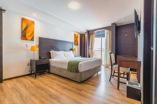 a hotel room with a bed and a desk and a desk at Zamorano Real Hotel in Loja