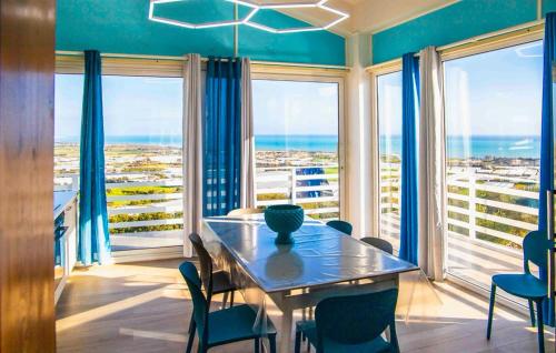 a dining room with a table and chairs and the ocean at Villa Sara in Ragusa