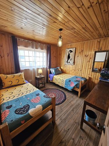 a bedroom with two beds in a wooden cabin at Hostal Sol y Luna - Descanso a 10 min del aeropuerto & Desayuno Incluido in Santiago
