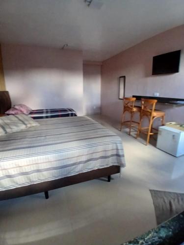 a bedroom with a bed and a table and a desk at Pousada Santa Maria in Canoinhas