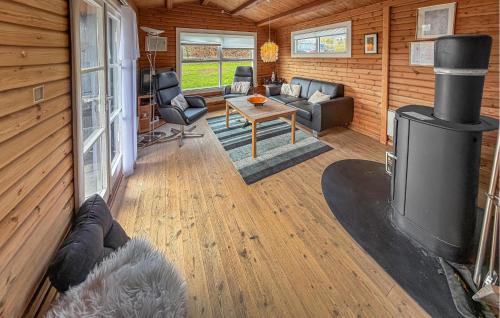 a living room with a fireplace in a log cabin at Nice Home In Broager With Wifi in Broager