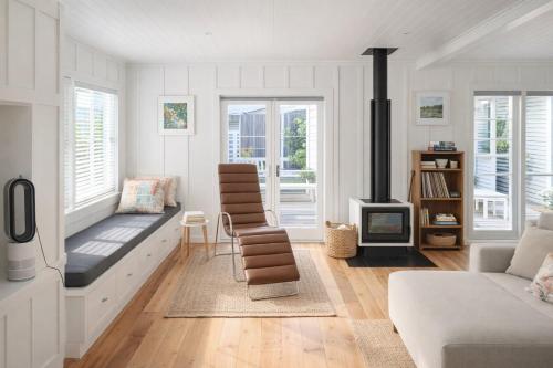 a living room with a couch and a fireplace at Raglan West Cottage, Surf Side Escape in Raglan