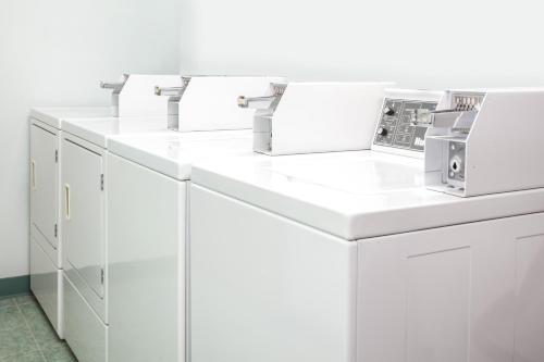 a row of white washing machines in a room at Super 8 by Wyndham Kindersley in Kindersley