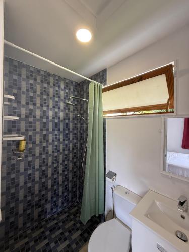 a bathroom with a toilet and a shower and a sink at Tuava - Mirimiri Lodge in Ataiti