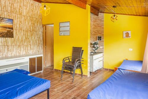 a room with two beds and a chair in it at Chácara lar e paz Mairinque in Mairinque