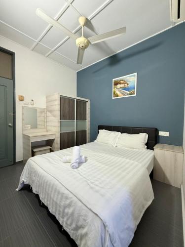 a bedroom with a large white bed with a ceiling fan at Ipoh Garden 4BR 10Pax in Ipoh
