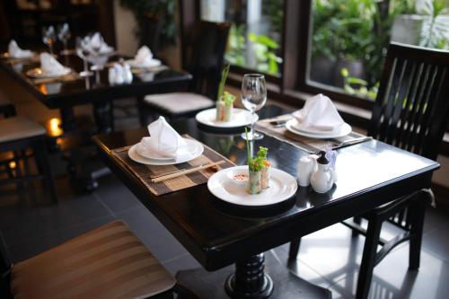 a table with plates and napkins on it in a restaurant at Goda Boutique Hotel in Hoi An