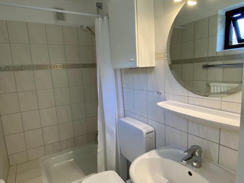 a bathroom with a toilet and a sink and a mirror at Lerchenweg Bungalow in Westerland