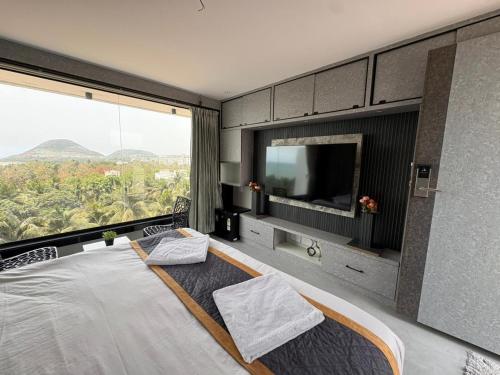 a bedroom with a large bed with a large window at Hotel SERENE PRAIA in Visakhapatnam