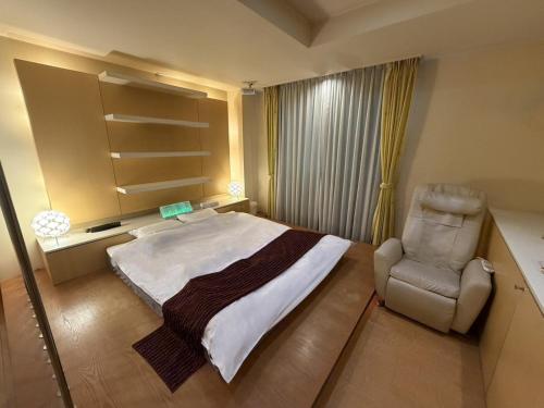 a bedroom with a large bed and a chair at HOTEL Le Grand in Matsuzaka