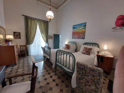 a bedroom with four beds and a table and chairs at Palazzo Degli Antoci in Ragusa