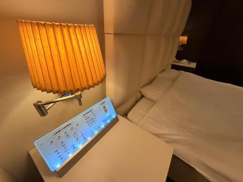 a laptop computer sitting on a table next to a bed at HOTEL Le Grand in Matsuzaka