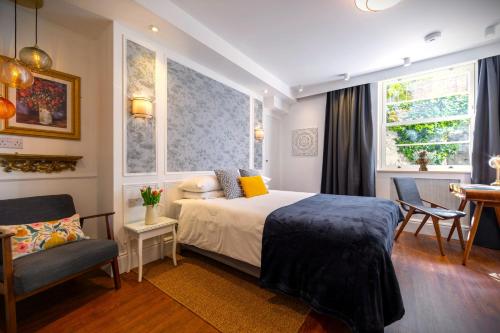 a bedroom with a bed and a chair and a window at Ferndale Mews in Bristol