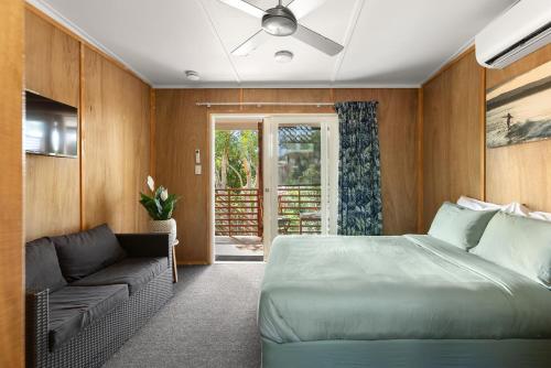 a bedroom with a bed and a couch at Dolphins Backpackers in Sunshine Beach