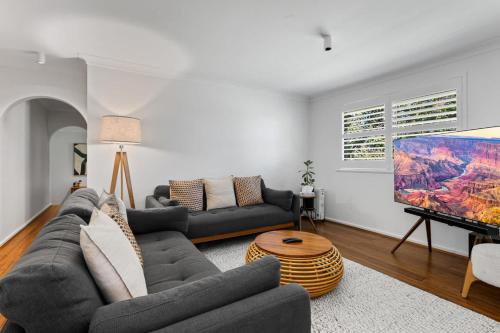 a living room with a couch and a tv at Bendalong - Rural Retreat, Short Drive to CBD in Orange