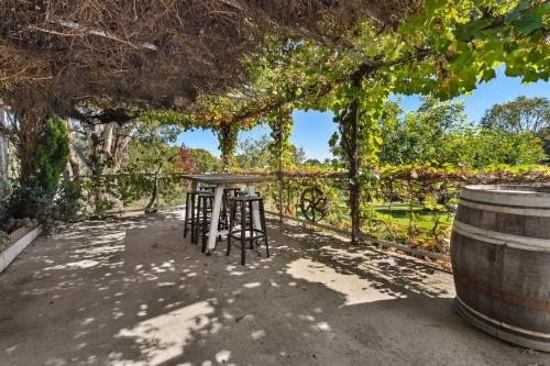 a table and two stools under a pergola at Bendalong - Rural Retreat, Short Drive to CBD in Orange