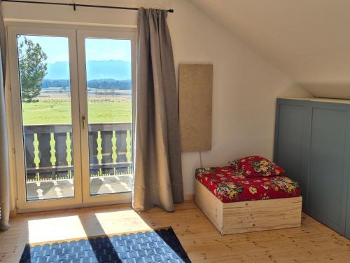 a bedroom with a bed and a large window at The Staffelsee Lodge in Uffing