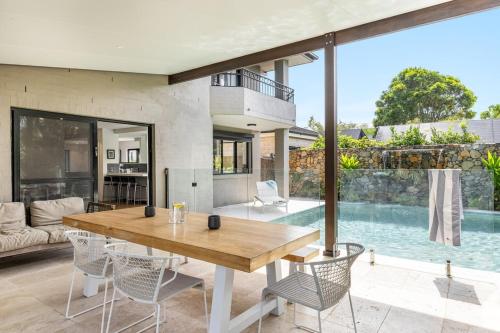 a living room with a wooden table and chairs at Stone & Sand in Lennox Head