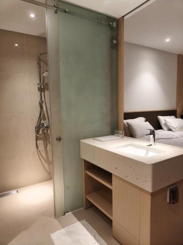a bathroom with a sink and a shower at Oceanview Apartment at Arena Cam Ranh Resort in Thôn Hòa Ða