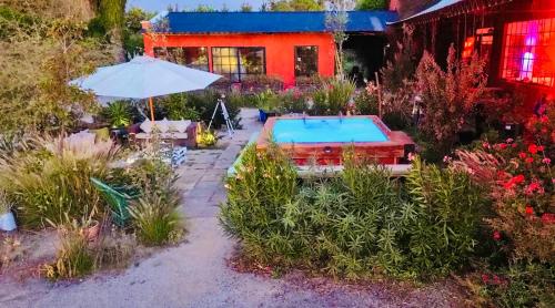 a house with a swimming pool in a garden at Strip Center Suites by Casona Lo Aguirre in El Monte