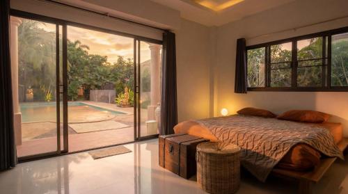 a bedroom with a bed and a large sliding glass door at Ayeda Villa 2 in Krabi