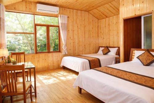 a bedroom with two beds and a table with a desk at Midtown homestay in Phong Nha