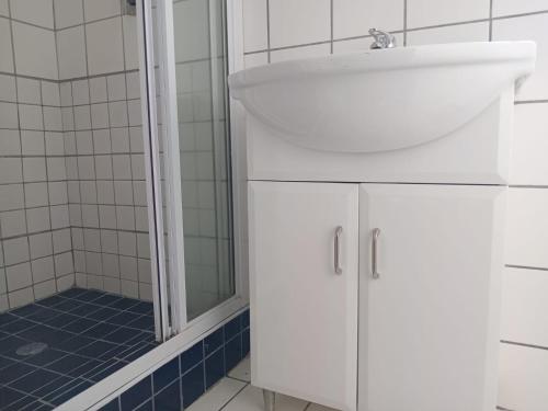 a white bathroom with a sink and a shower at UVongo Welcome House in Margate