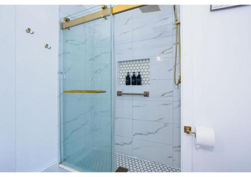 a shower with a glass door in a bathroom at Spacious Home Near Starland, River St & DT - Arcade in Savannah