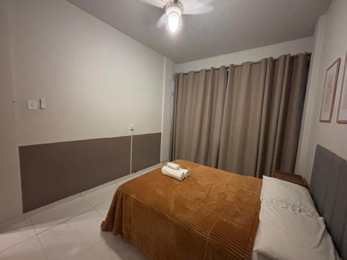 a bedroom with a bed with two towels on it at Apto no Centro de Miguel Pereira in Miguel Pereira