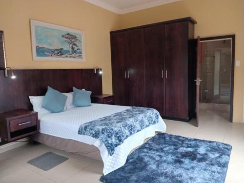 a bedroom with a large bed with a wooden headboard at UVongo Welcome House in Margate
