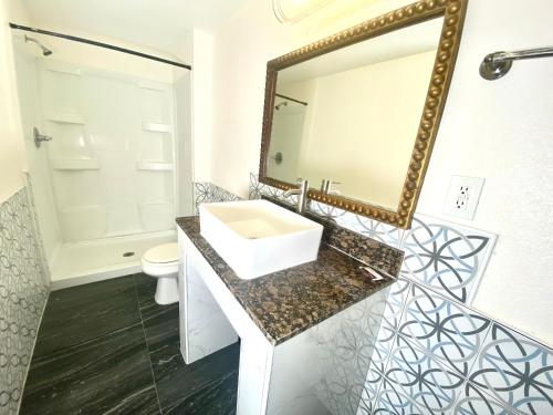 a bathroom with a sink and a mirror at Long Beach Motel in Long Beach