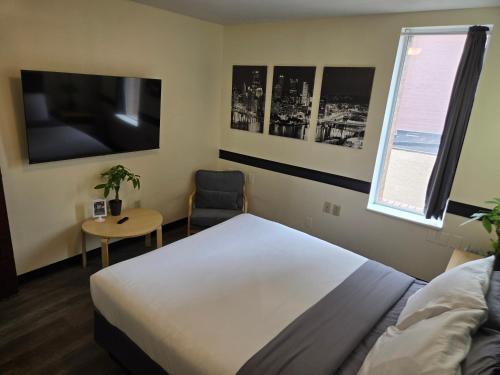 a bedroom with a bed and a table and a chair at Stay Pittsburgh in Pittsburgh
